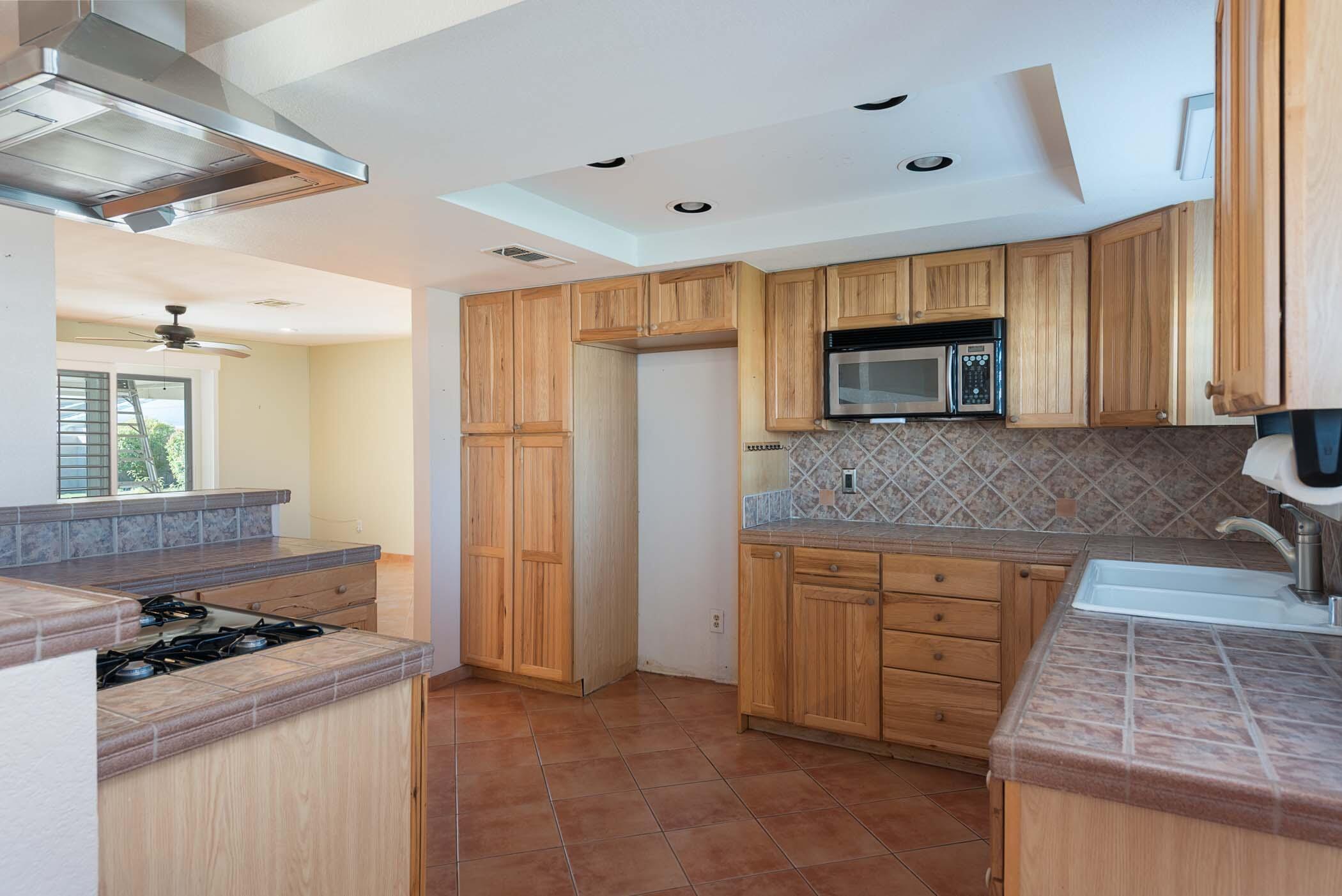 67705 Ovante Road Cathedral City, CA 92234 - Photo 13 of 34 a kitchen with granite countertop a sink stove and refrigerator