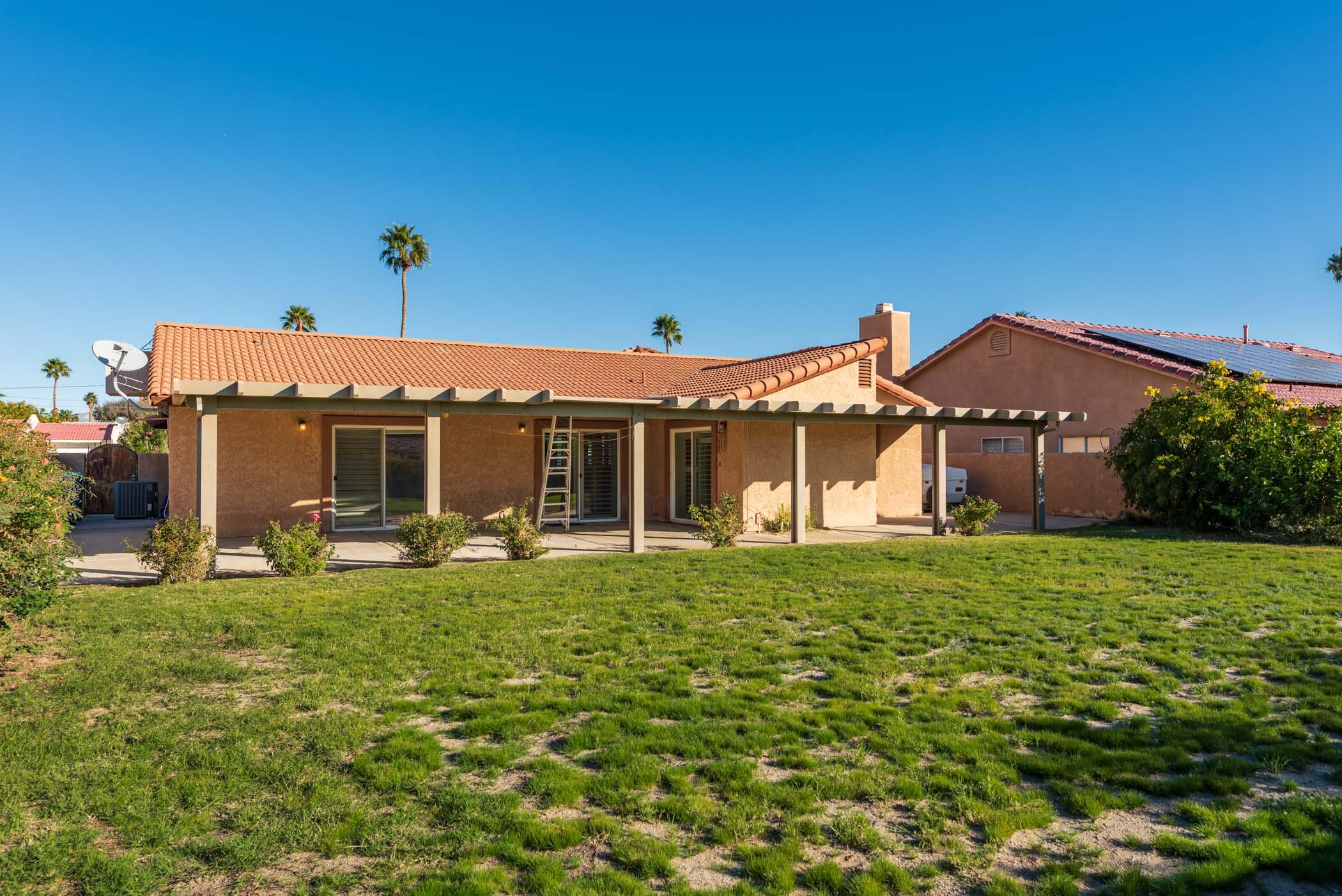 67705 Ovante Road Cathedral City, CA 92234 - Photo 29 of 34 a front view of a house with a garden and yard