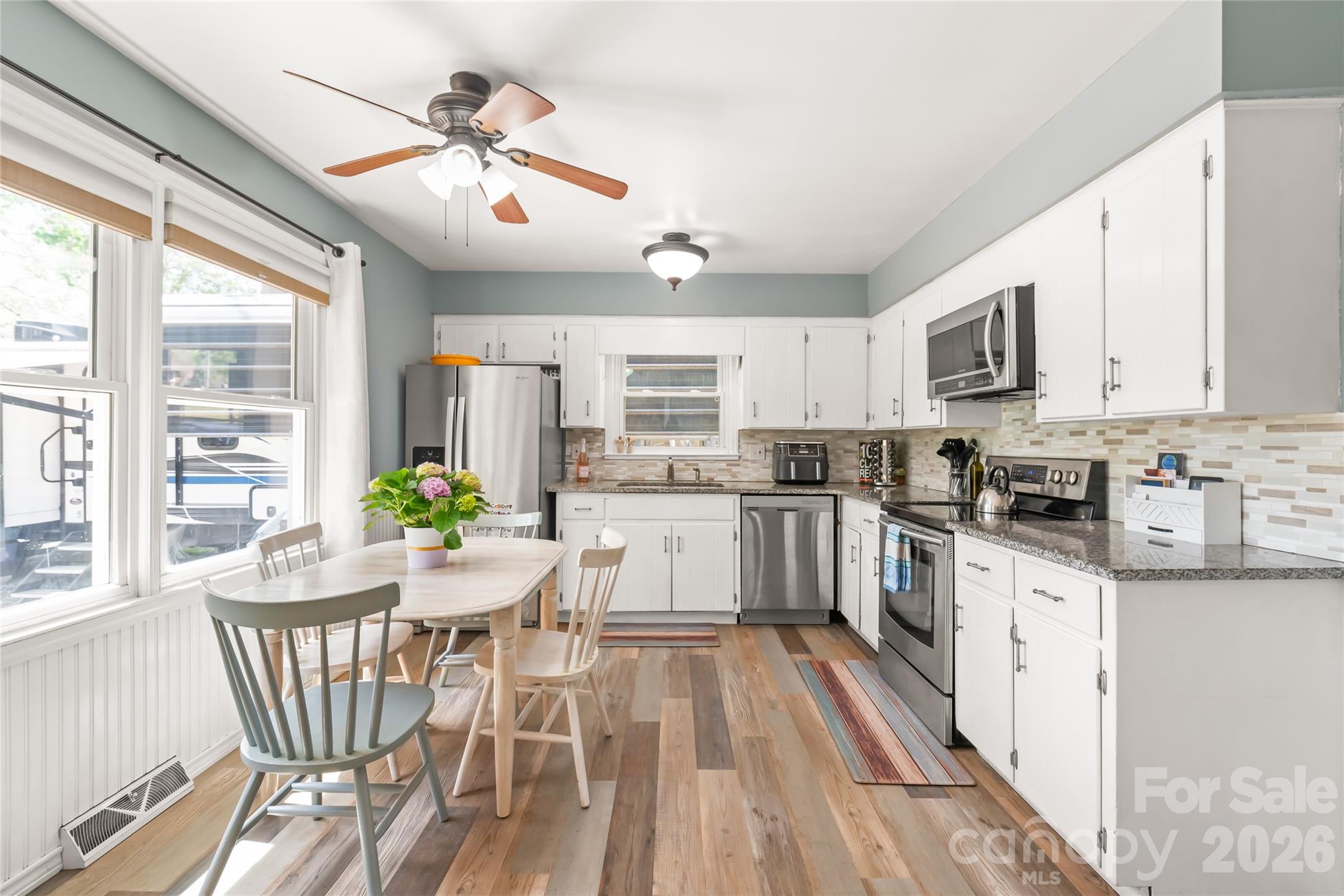 104 Pine Tree Drive Fort Mill, SC 29715 - Photo 7 of 35 a kitchen with granite countertop stainless steel appliances cabinets a dining table and a chandelier