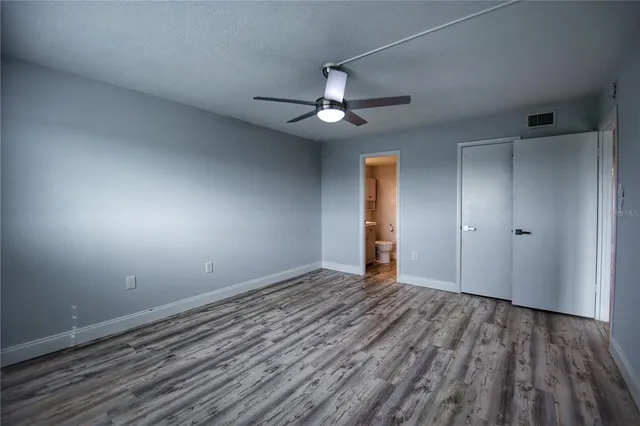 a view of a room with wooden floor fan and window