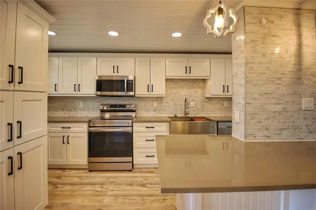 a kitchen with stainless steel appliances granite countertop a stove a sink and a microwave