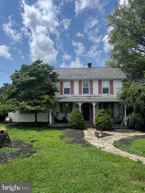 a front view of a house with garden and trees