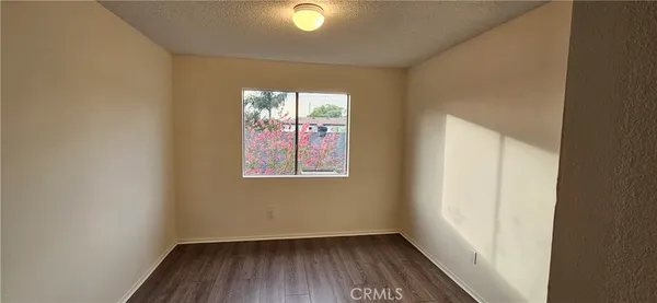 a view of hallway with window and wooden floor