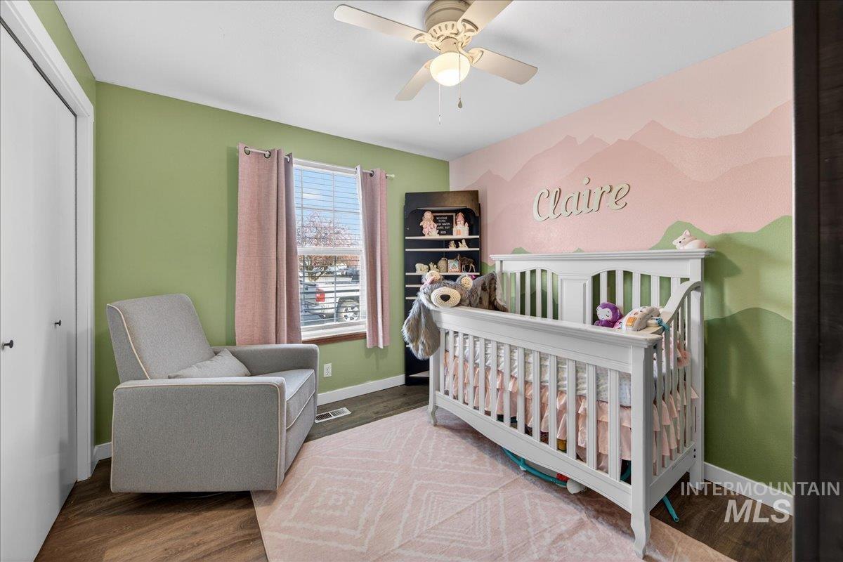 611 Northwest 15th Street Meridian, ID 83642 - Photo 13 of 35 Bedroom featuring a nursery area, ceiling fan, and wood finished floors