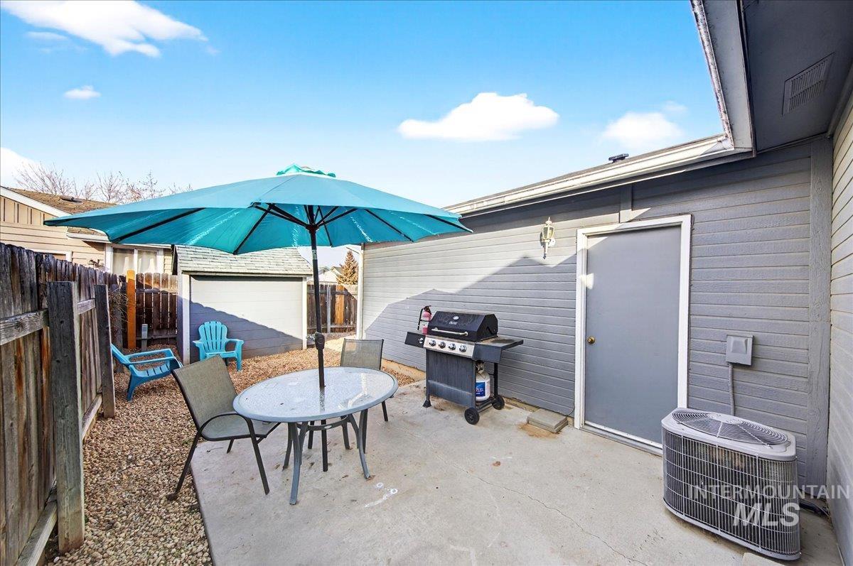 611 Northwest 15th Street Meridian, ID 83642 - Photo 25 of 35 Fenced backyard with a patio area, area for grilling, outdoor dining space, and an outbuilding
