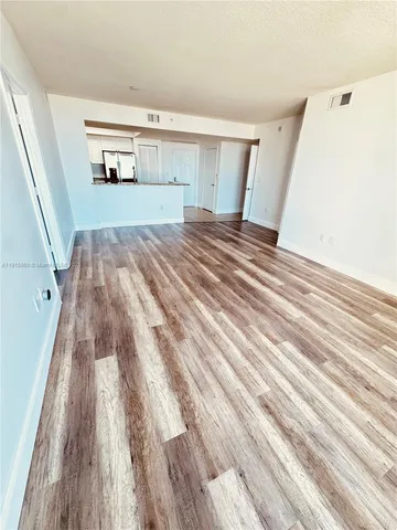 a view of a livingroom with wooden floor and a fireplace