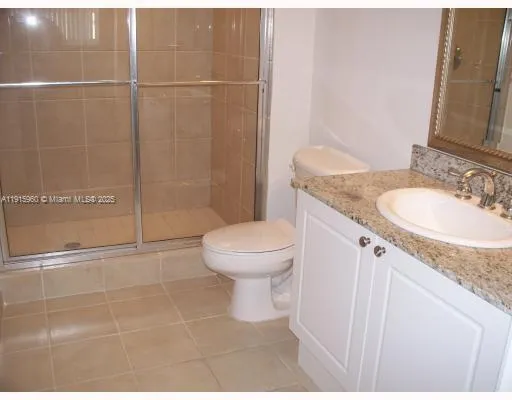 a bathroom with a glass door shower a toilet and a sink