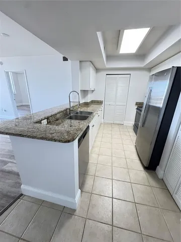 a kitchen with a sink dishwasher a refrigerator and a stove