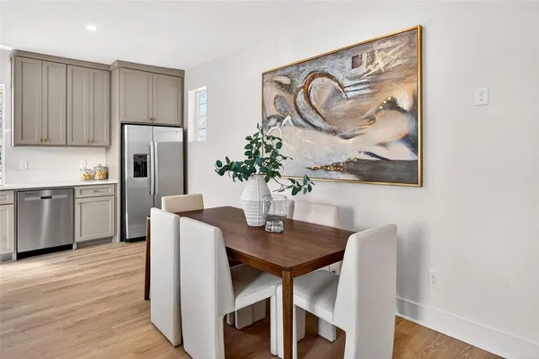 a living room with stainless steel appliances furniture a fireplace and a potted plant