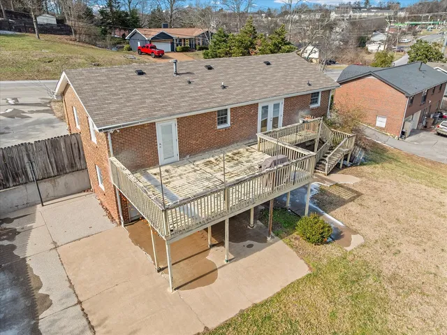 aerial view of a house with a yard and large trees