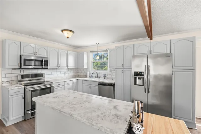a kitchen with stainless steel appliances kitchen island a refrigerator sink and stove