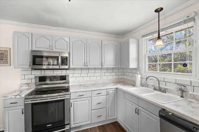 a kitchen with granite countertop a sink stainless steel appliances and cabinets