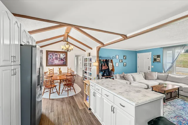 a living room with furniture a dining table and chairs with wooden floor
