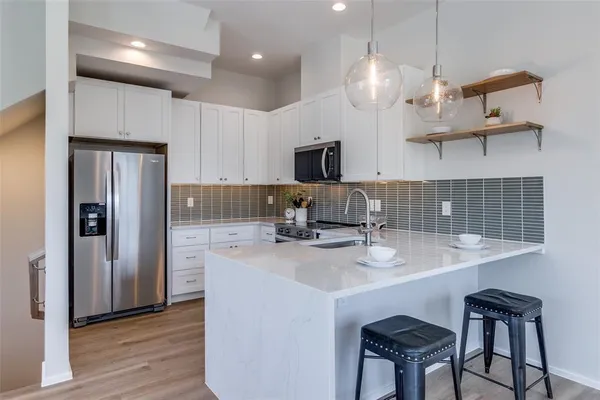 a kitchen with kitchen island a counter space a sink appliances and cabinets