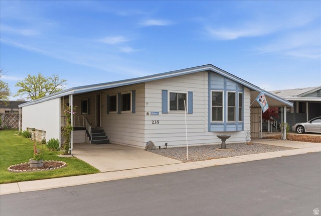 3800 South 1900 West, Unit 235 Roy, UT 84067 - Photo 1 of 1 View of front of house with a carport, concrete driveway, entry steps, and a front yard