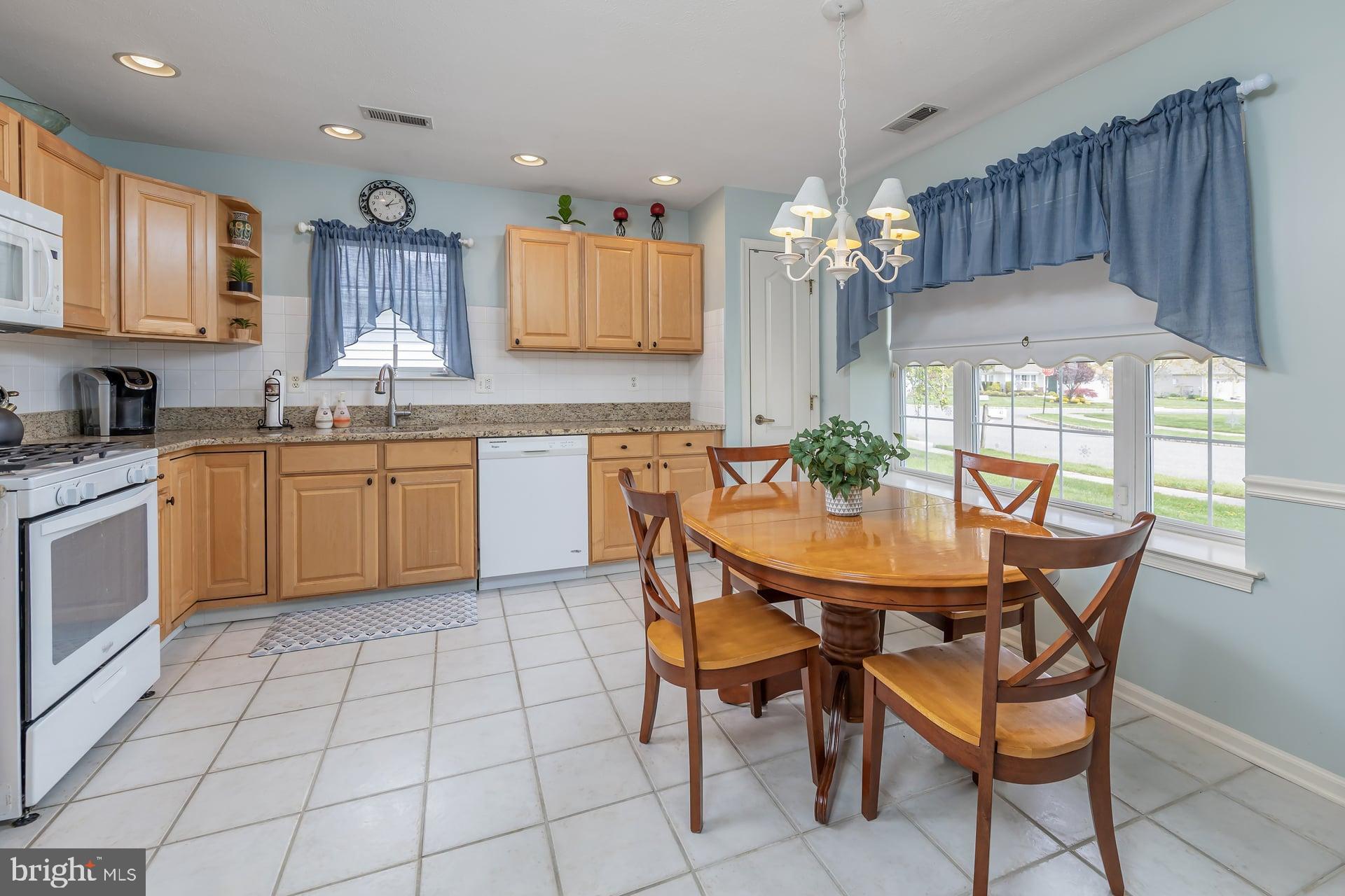 41 Grandview Place Sewell, NJ 08080 - Photo 8 of 23 a kitchen with stainless steel appliances granite countertop a sink a stove a dining table and chairs