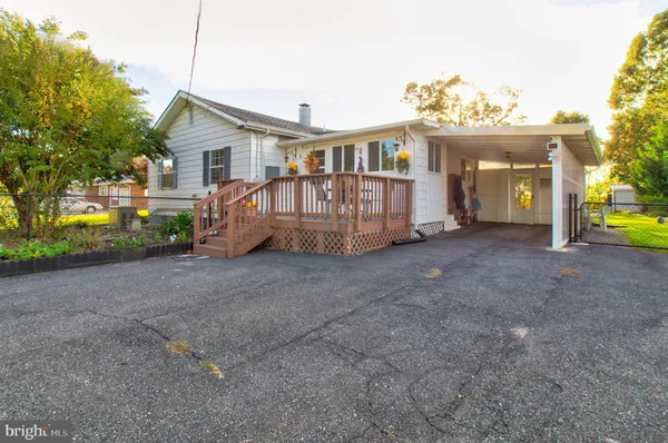 a view of a house with a yard and deck area