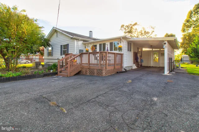 a view of a house with a yard and deck area