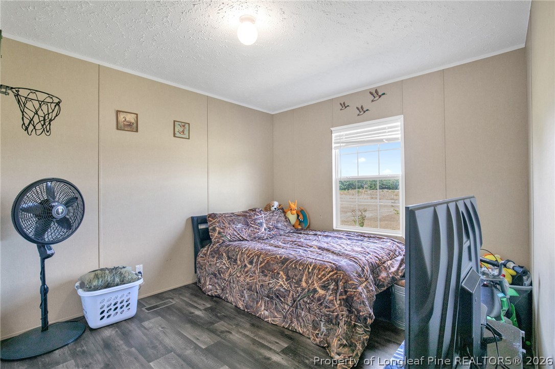 2452 Progressive Farm Road Fairmont, NC 28340 - Photo 23 of 39 a bedroom with a bed window and a chandelier
