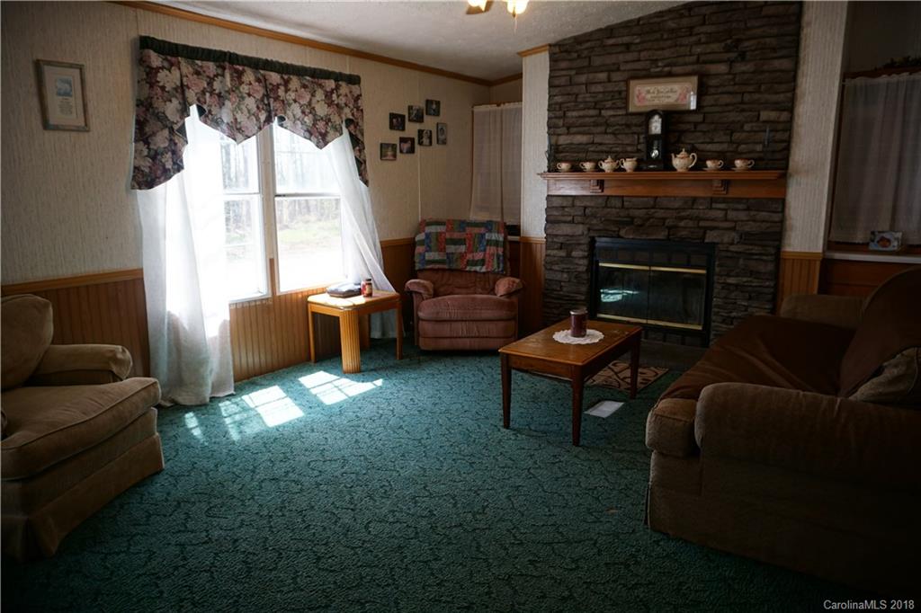 1042 Elliott Road Rutherfordton, NC 28139 - Photo 25 of 33 a living room with furniture a fireplace and a floor to ceiling window