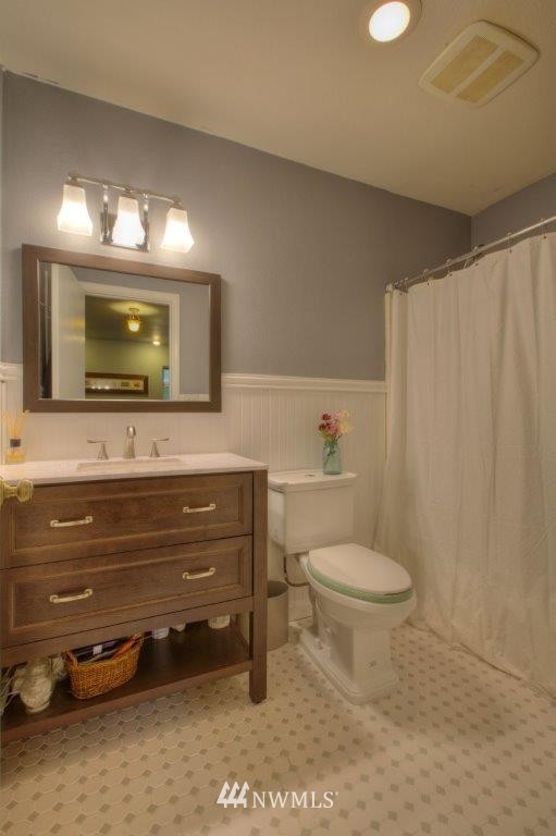 1114 Northeast 145th Street Shoreline, WA 98155 - Photo 13 of 19 a bathroom with a toilet a sink and a mirror