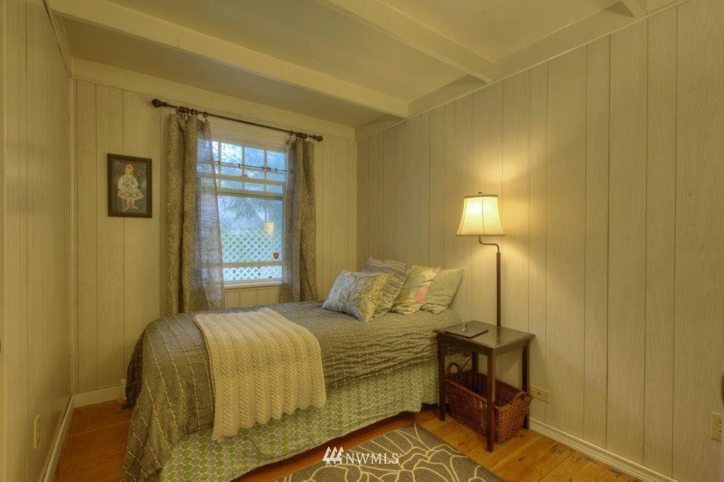 1114 Northeast 145th Street Shoreline, WA 98155 - Photo 14 of 19 a bedroom with a bed and lamp next to a window