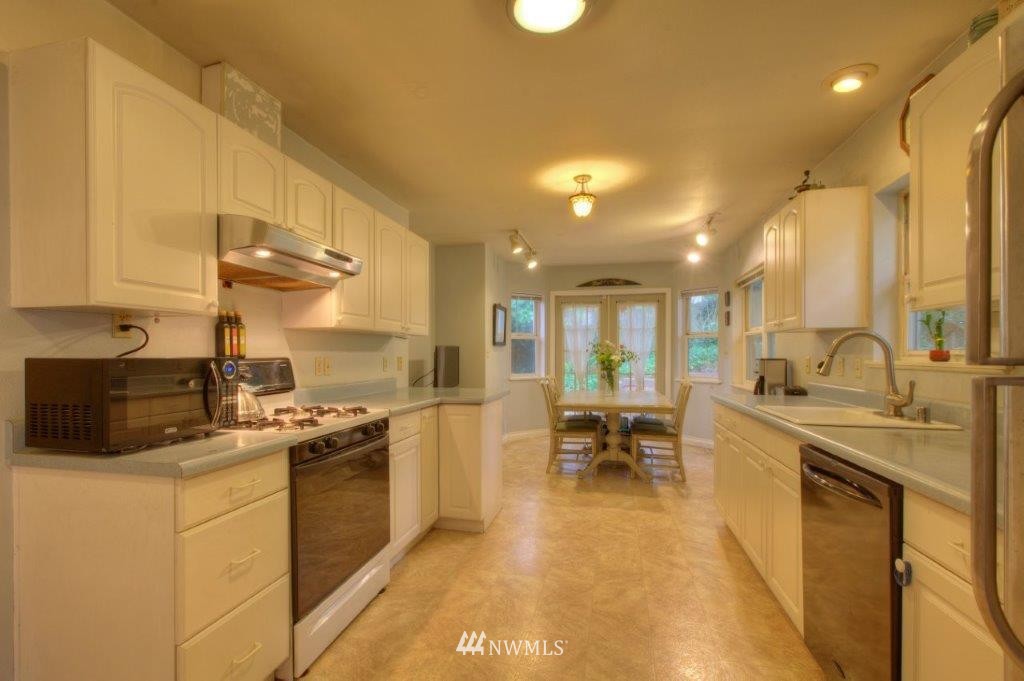 1114 Northeast 145th Street Shoreline, WA 98155 - Photo 8 of 19 a kitchen with a sink stove and cabinets
