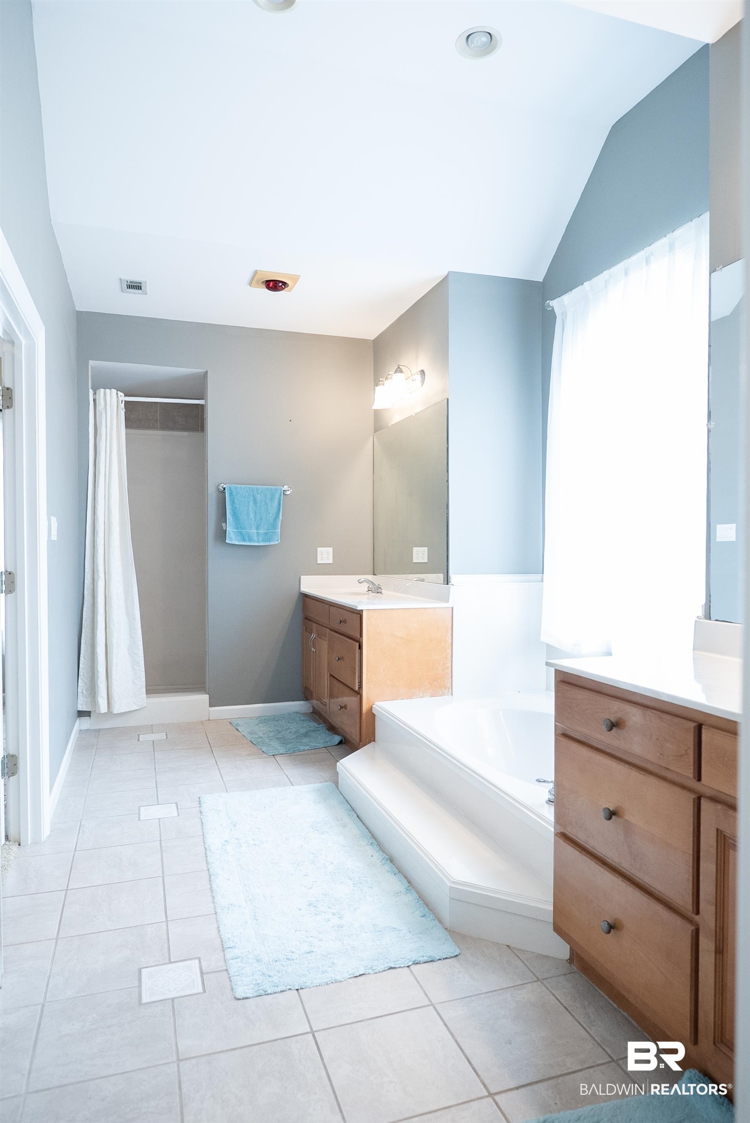 10023 Springfield Court Mobile, AL 36695 - Photo 33 of 50 Bathroom featuring a bath, vanity, a shower with shower curtain, light tile patterned floors, and vaulted ceiling