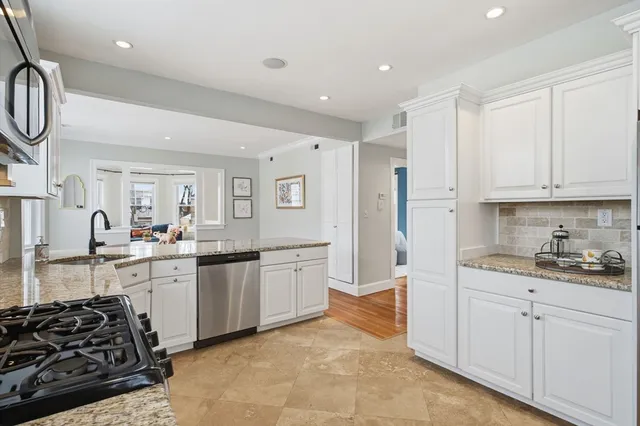 a kitchen with granite countertop a stove a sink and a microwave