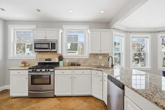 a kitchen with stainless steel appliances granite countertop a sink and cabinets