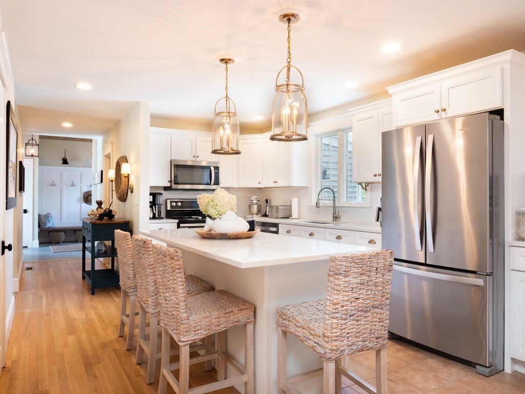 740 Reed Road Dartmouth, MA 02747 - Photo 12 of 26 a kitchen with stainless steel appliances a refrigerator a sink dishwasher a stove and a dining table with wooden floor