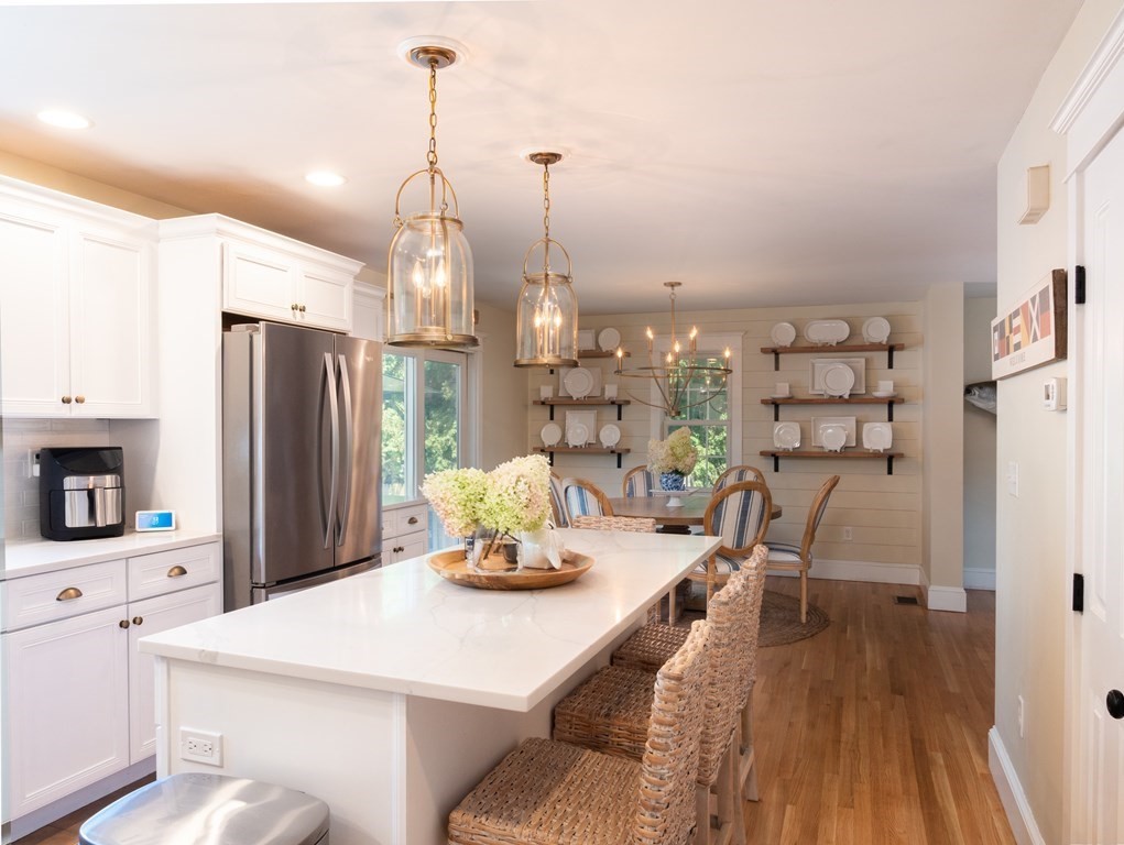 740 Reed Road Dartmouth, MA 02747 - Photo 14 of 26 a kitchen with stainless steel appliances kitchen island granite countertop a refrigerator a stove a sink dishwasher and a dining table with wooden floor