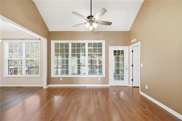 an empty room with wooden floor and ceiling fan