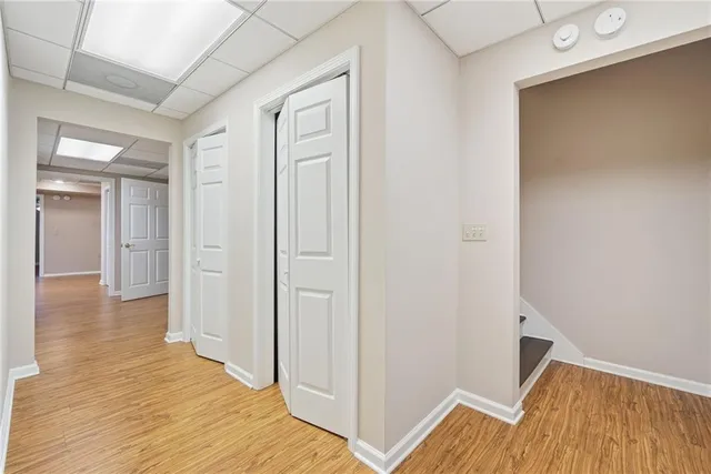 a room with wooden floor pool table and windows
