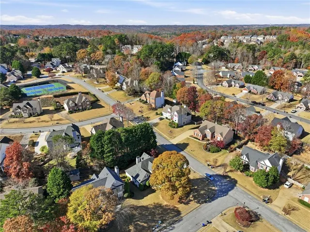 a view of a livingroom with wooden floor a ceiling fan and windows