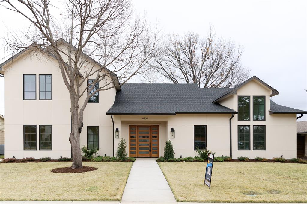 a front view of a house with yard and glass windows