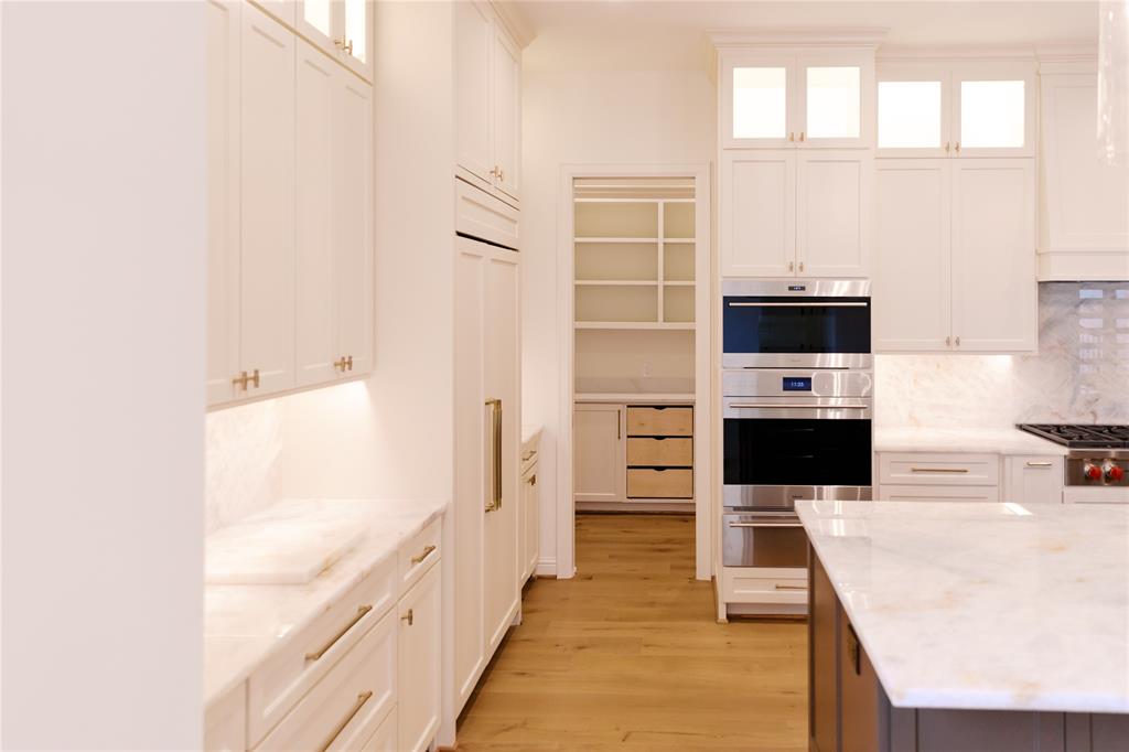 10930 Beauty Lane Dallas, TX 75229 - Photo 7 of 27 a kitchen with stainless steel appliances kitchen island wooden cabinets and a window