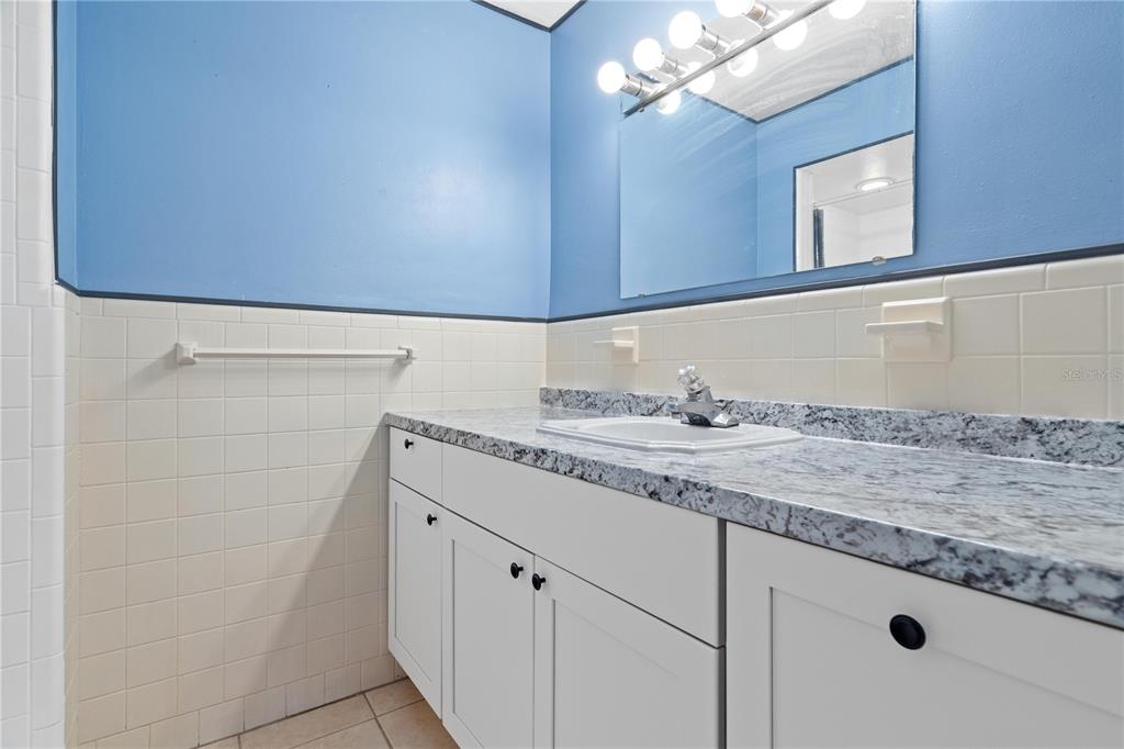 10 Kepner Street Orlando, FL 32839 - Photo 15 of 26 a bathroom with a granite countertop sink and a mirror