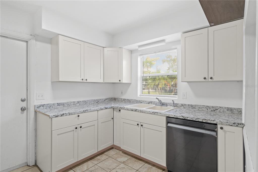 10 Kepner Street Orlando, FL 32839 - Photo 7 of 26 a kitchen with stainless steel appliances granite countertop white cabinets sink and window