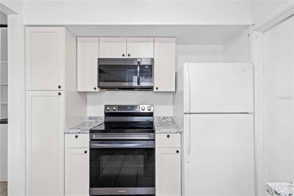 10 Kepner Street Orlando, FL 32839 - Photo 8 of 26 a kitchen with a refrigerator stove and microwave