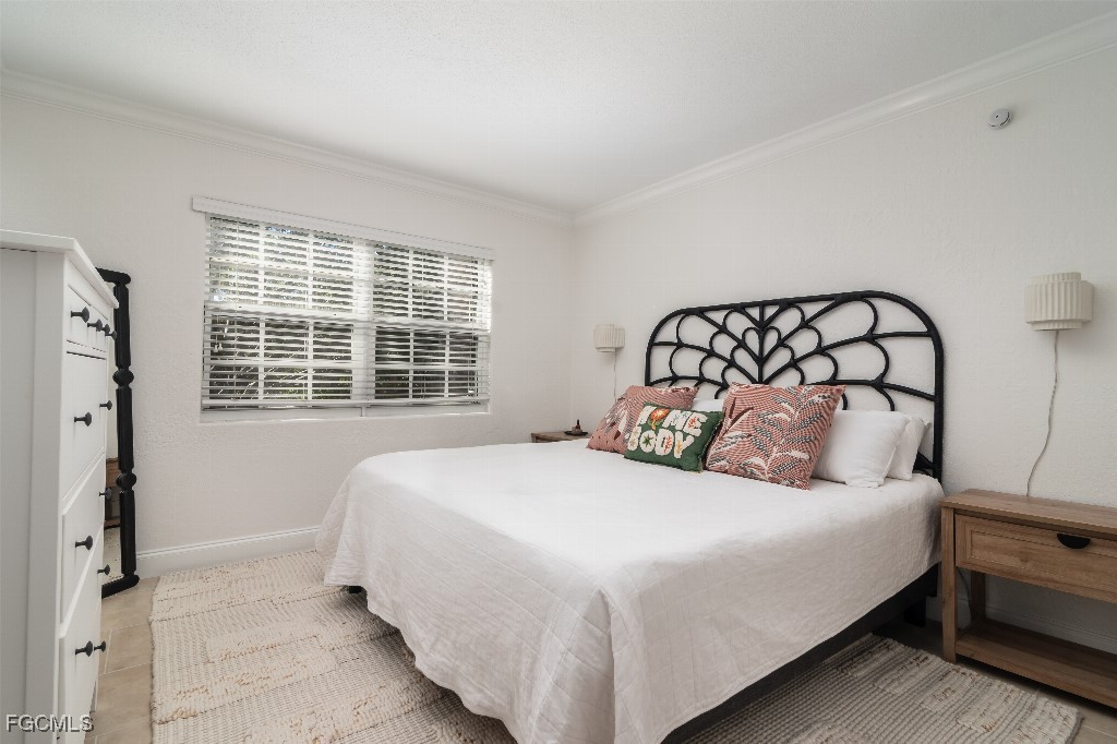 72 7th Street South, Unit 206 Naples, FL 34102 - Photo 8 of 10 a large bed sitting in a bedroom next to a window