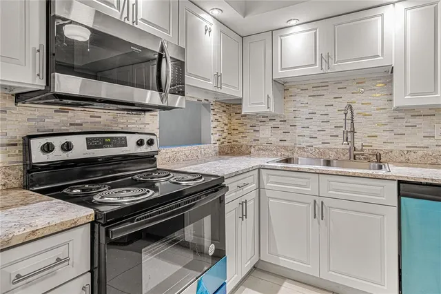 a kitchen with granite countertop cabinets stainless steel appliances and sink