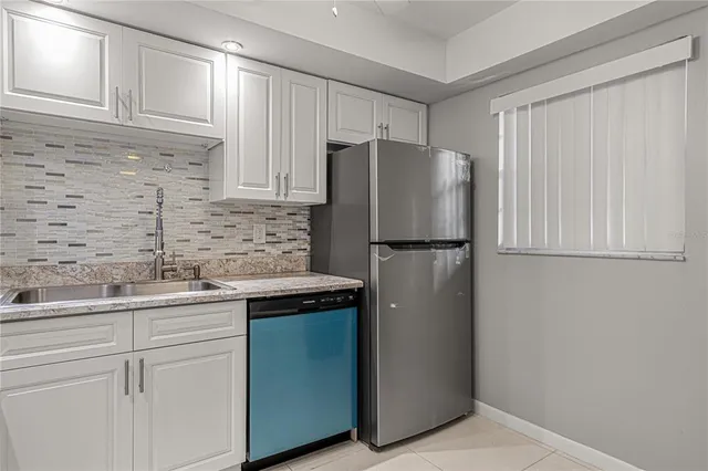 a kitchen with stainless steel appliances granite countertop a refrigerator and a sink
