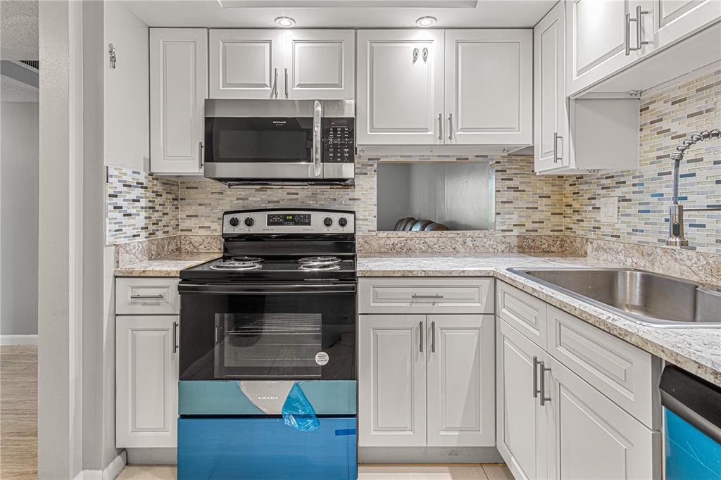 640 North Nova Road, Unit 409 Ormond Beach, FL 32174 - Photo 6 of 33 a kitchen with appliances a sink and cabinets