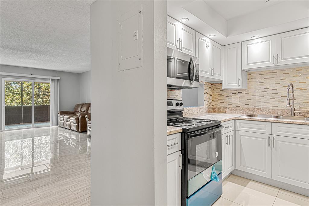 640 North Nova Road, Unit 409 Ormond Beach, FL 32174 - Photo 7 of 33 a kitchen with granite countertop a stove and a sink