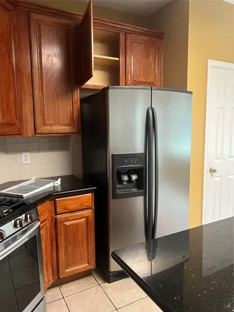 a kitchen with stainless steel appliances granite countertop a refrigerator and a stove