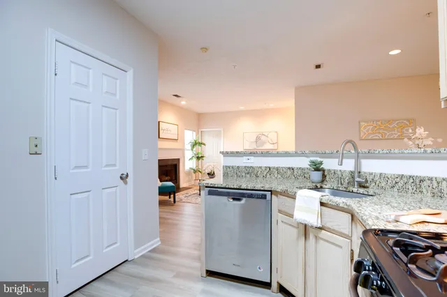 a open hall with stainless steel appliances granite countertop a stove and cabinets