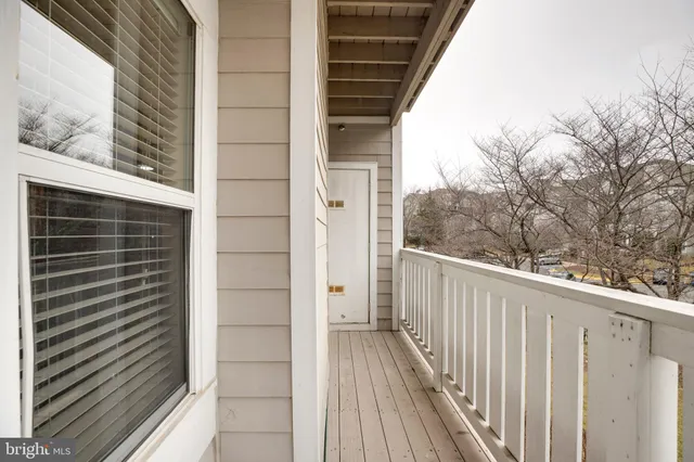 a view of a balcony with wooden floor and fence