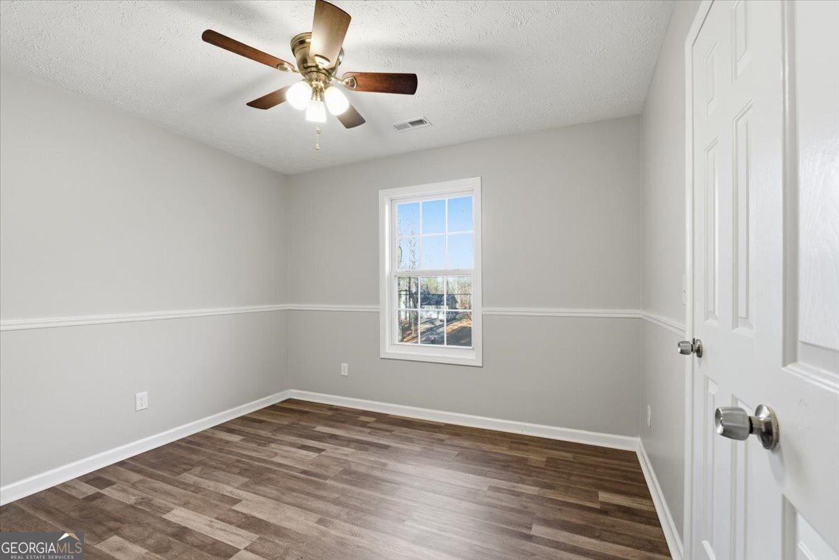 93 Robin Hood Road Covington, GA 30014 - Photo 11 of 20 an empty room with a window and a ceiling fan