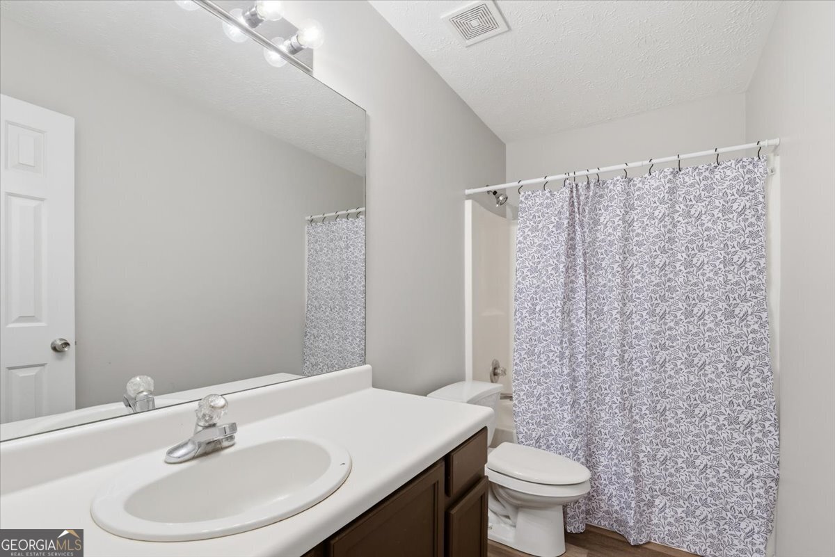 93 Robin Hood Road Covington, GA 30014 - Photo 12 of 20 a bathroom with a sink a toilet and a mirror